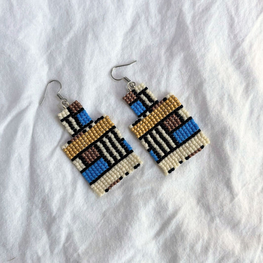 Cercei handmade din mărgele fine, model geometric dreptunghiular cu influențe etnice, combinație de albastru, crem, maro și auriu, cercei statement ușori, bijuterii artizanale unicat, stil boho modern, ideali pentru ținute casual sau elegante.