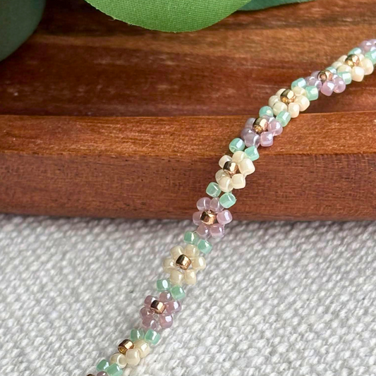Martisor bratara fina realizata manual, cu flori mici din margele pastel si detalii aurii. Inchidere cu carabina, perfecta pentru cadou de 1-8 Martie si pentru tinute minimaliste.