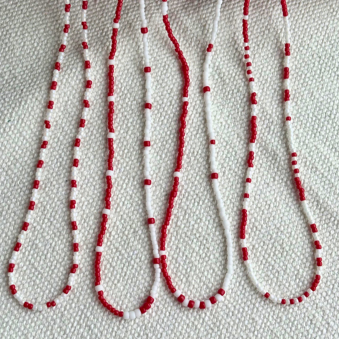 Patru coliere Martisor rosu-alb din margele fine, realizate manual, modele similare si delicate. Perfecte pentru cadouri multiple de 1 Martie (colege, prietene) si pentru tinute minimaliste de primavara.