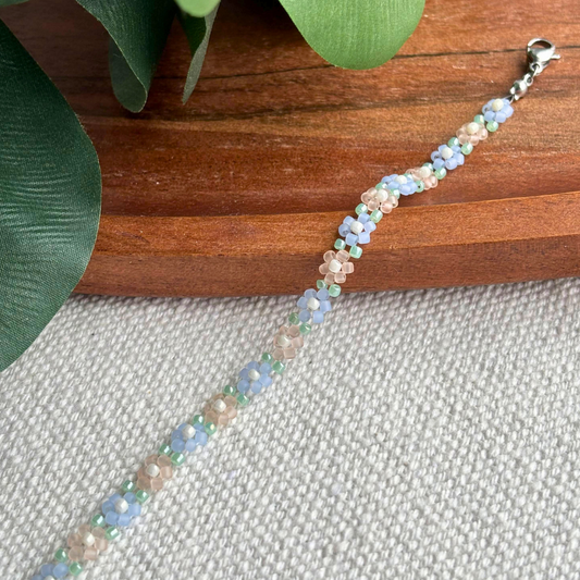 Bratara Martisor handmade cu floricele pastel bleu, verde menta si nude din margele. Cadou delicat pentru 1-8 Martie, perfect de purtat zilnic.