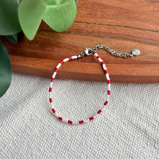 Bratara Martisor rosu si alb, lucrata manual din margele fine, cu inchidere reglabila. Cadou simplu si elegant pentru 1 Martie, usor de purtat zilnic.