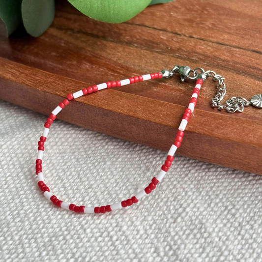 Bratara Martisor rosu-alb din margele fine, lucrata manual, cu lant de prelungire reglabil. Cadou discret si elegant pentru 1 Martie, perfecta pentru purtare zilnica.