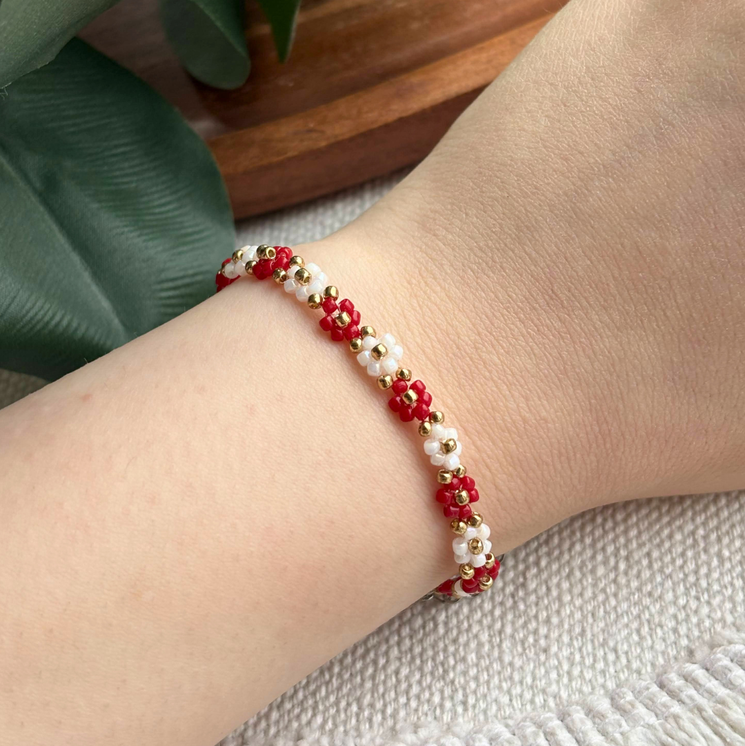 Bratara de primavara cu flori rosii si albe din margele, realizata manual, cu finisaj elegant. Martisor modern, gata de oferit cadou unei persoane dragi.