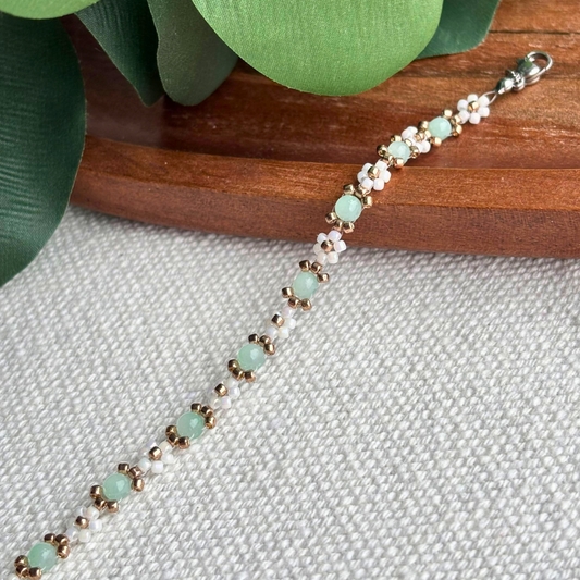 Bratara fina cu margele albe irizate si accente verde menta, realizata manual. Martisor elegant de purtat zilnic sau de oferit cadou, se potriveste la orice tinuta.
