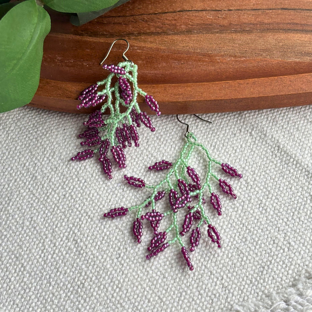 Pereche de cercei florali din margele de sticla, verde menta cu accente mov, design tip ramura, cercei deosebiti handmade, potriviti pentru tinute casual sau elegante si martisor.