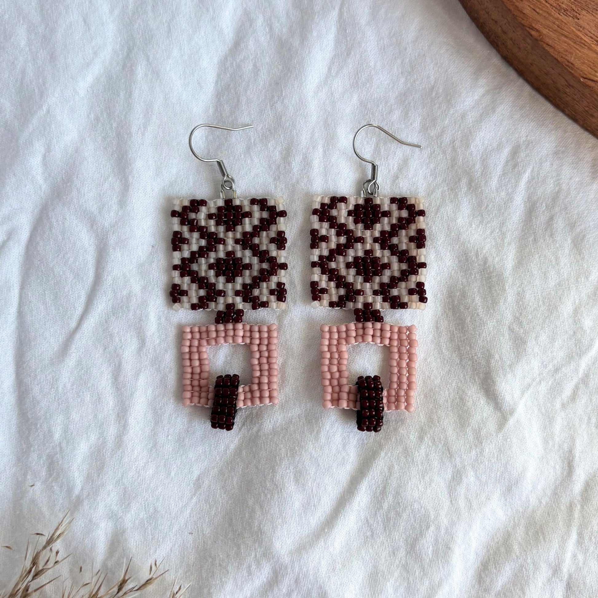 Cercei handmade din mărgele cu design geometric în culori burgundy, alb și roz pudrat, ușori, confortabili, boemi si sofisticați, accesorii statement, casual, eleganți, bijuterii artizanale lucrate manual în stil contemporan.