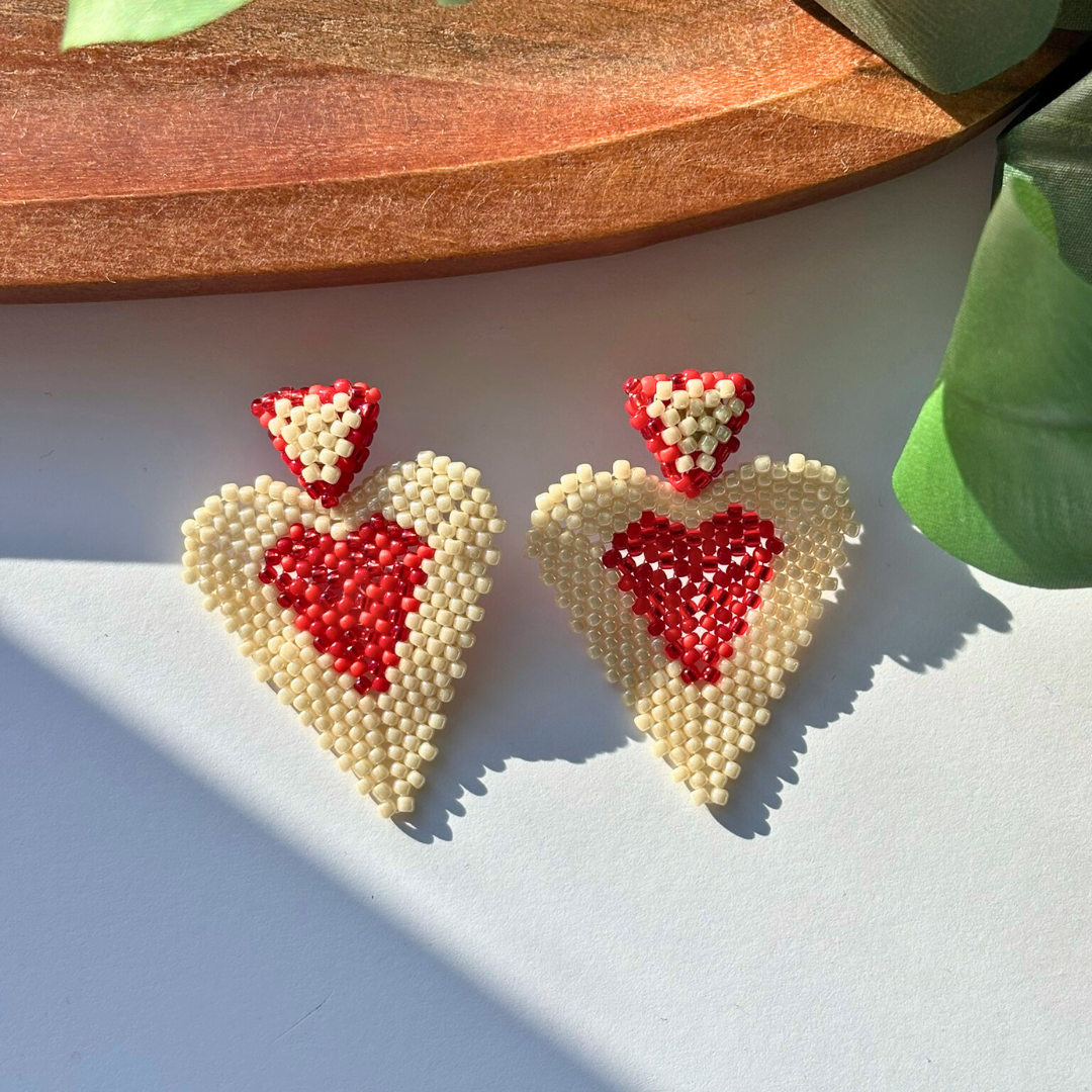 Cercei handmade în formă de inimă, realizați din mărgele crem cu interior roșu, design statement și romantic – bijuterii lucrate manual, ideale pentru cadou de Valentine’s Day sau ocazii speciale.