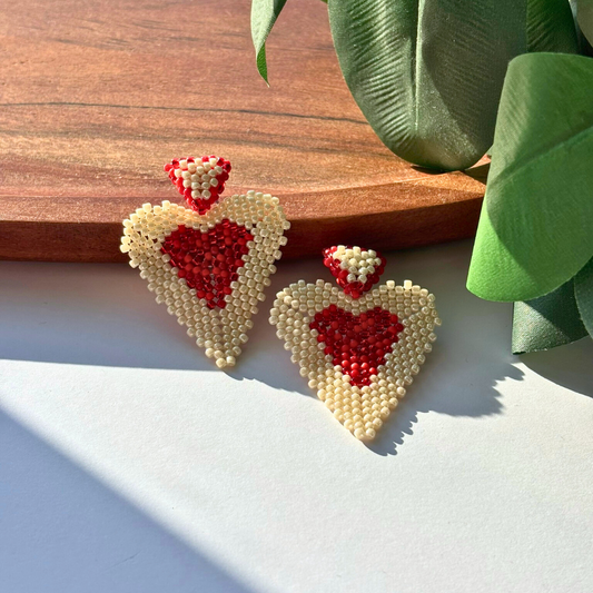 Cercei handmade lucrați manual în formă de inimă, din mărgele crem cu interior roșu, design romantic și statement – bijuterii ideale pentru cadou de Valentine’s Day sau ocazii speciale.