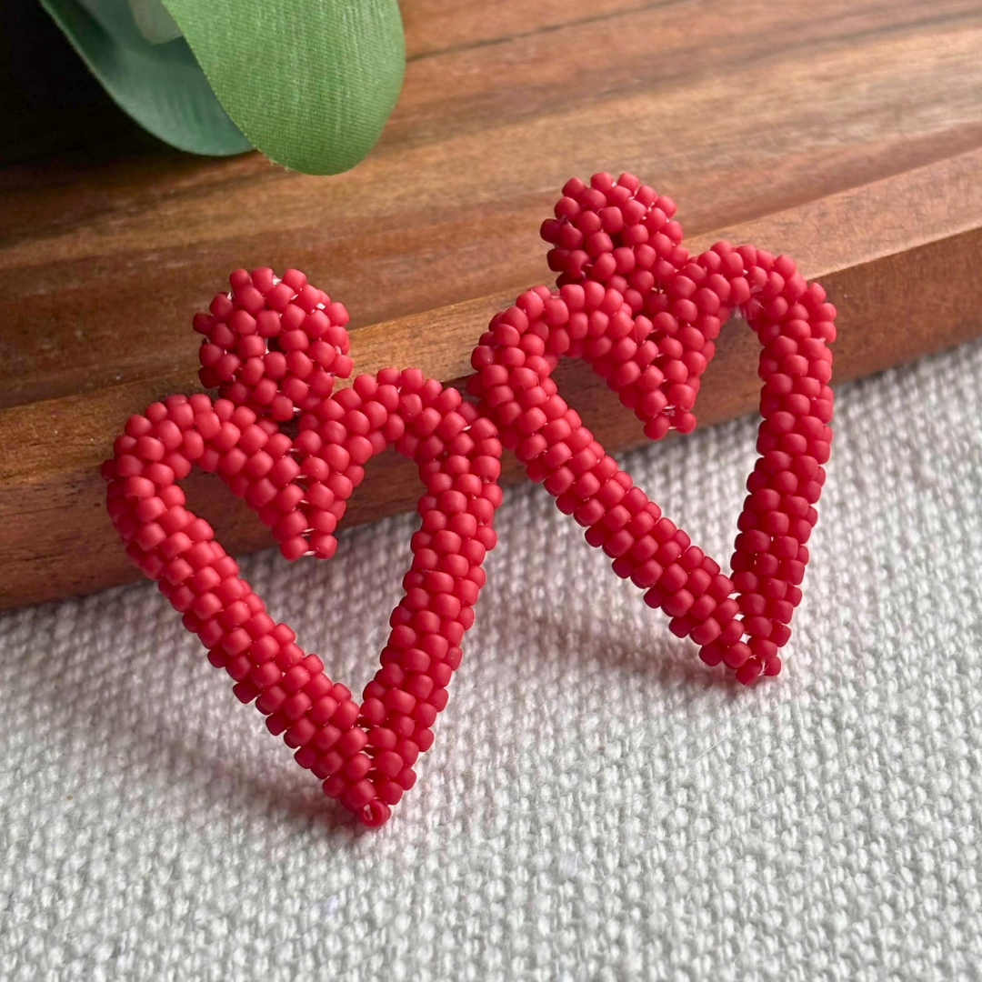 Cercei lucrati manual în formă de inimă, realizați din mărgele roz prăfuit, cu design delicat și feminin – accesorii romantice handmade ideale pentru cadou sau ocazii speciale.