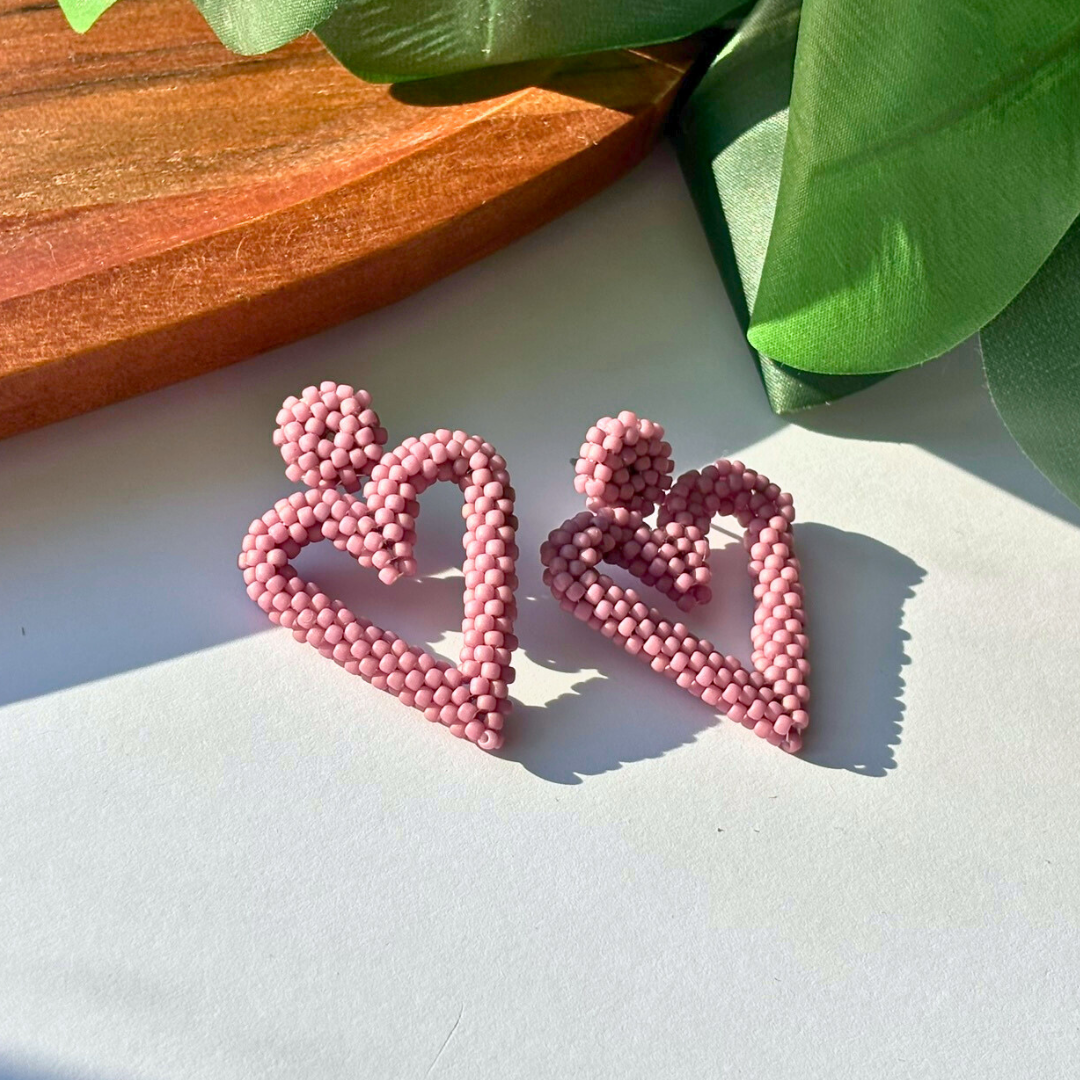 Cercei handmade statement în formă de inimă, realizați din mărgele roz prăfuit, design modern și romantic – accesorii feminine lucrate manual ideale pentru cadou sau ținute speciale.