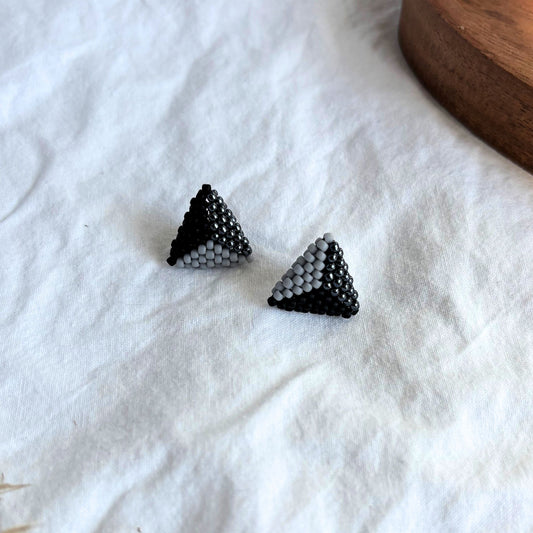 Cercei stud triunghiulari handmade din mărgele, combinație elegantă de negru, gri și accente lucioase, design geometric modern, bijuterii artizanale minimaliste pentru femei, potrivite pentru ținute casual sau elegante.