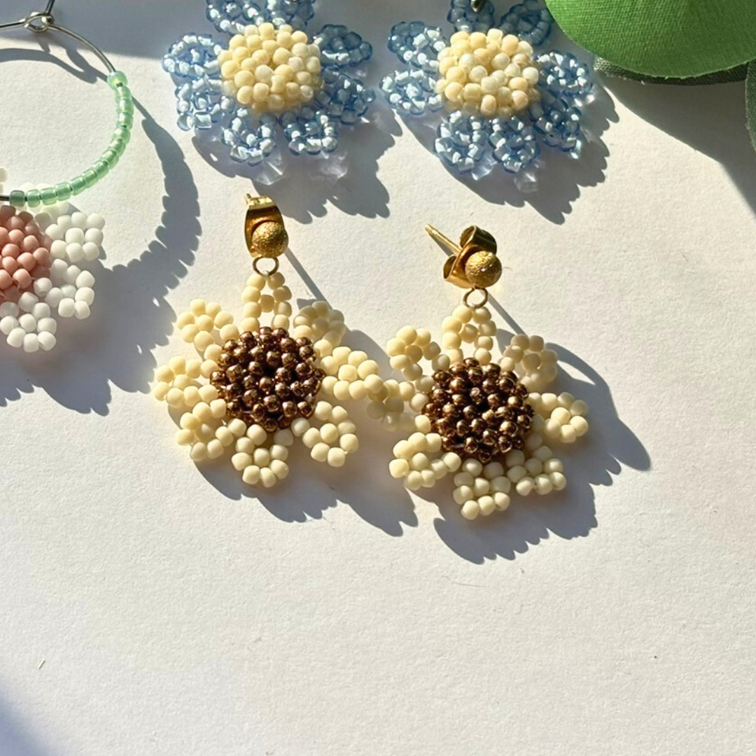 Cercei handmade în formă de margaretă, din mărgele crem cu centru maro și prindere tip șurub aurie – bijuterii florale delicate, perfecte pentru primăvară/vară și cadou.