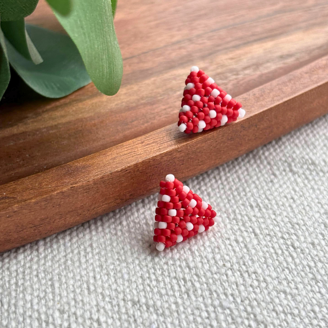 Cercei mici din margele rosii si albe, forma triunghi, lucrati manual in serie mica. Un Martisor modern si feminin, gata de purtat sau de daruit.