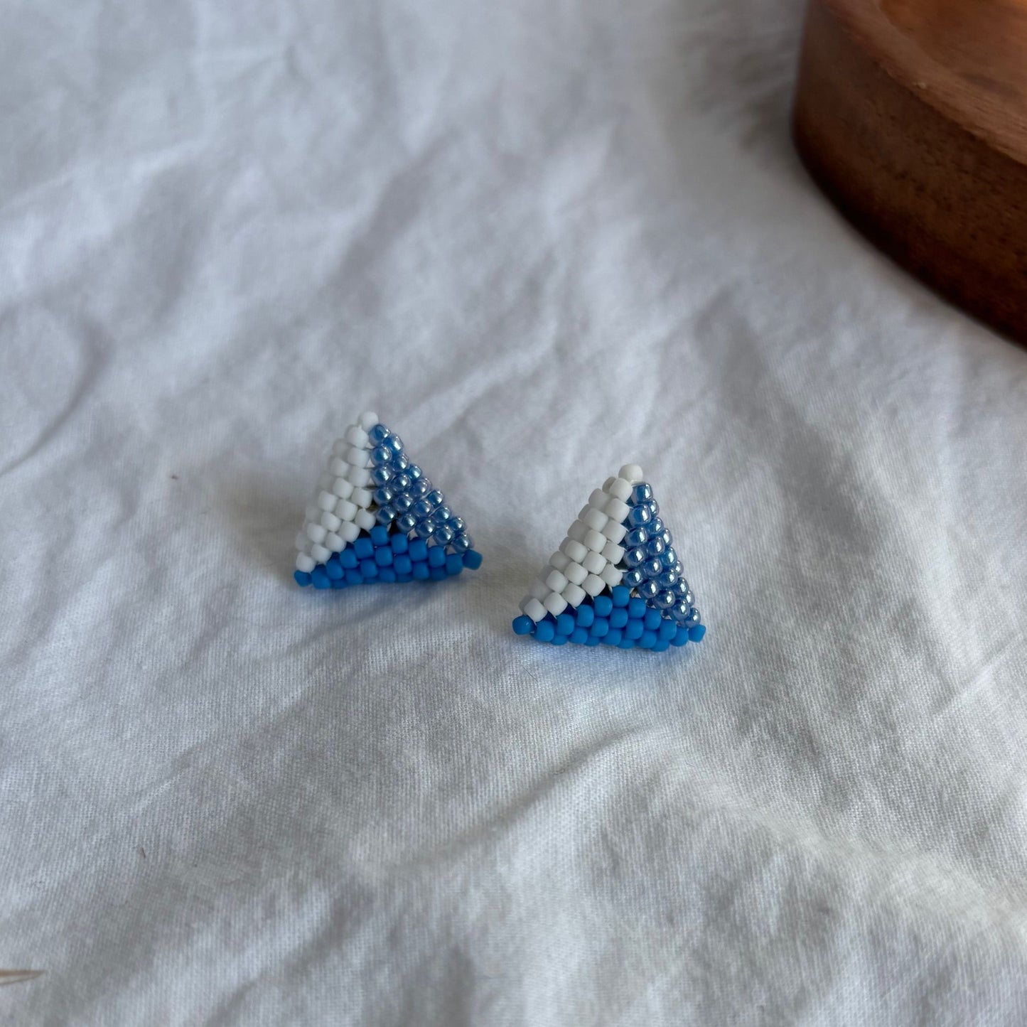 Cercei stud triunghiulari handmade din mărgele, combinație de alb, albastru intens și mărgele lucioase, design geometric minimalist, bijuterii artizanale ușoare pentru femei, ideale pentru ținute de zi sau cadou special.