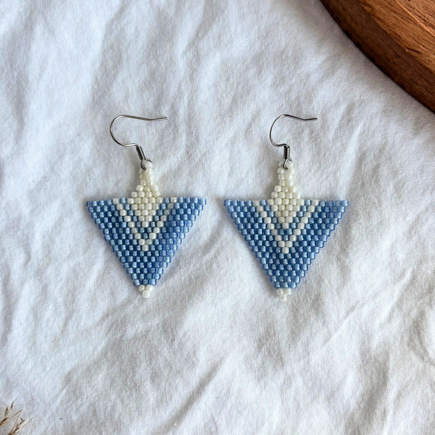 Cercei handmade din mărgele, model triunghiular geometric în nuanțe de albastru ciel și alb, realizați manual, ușori și moderni, bijuterii artizanale statement pentru femei, potriviți pentru ținute de zi sau ocazii.
