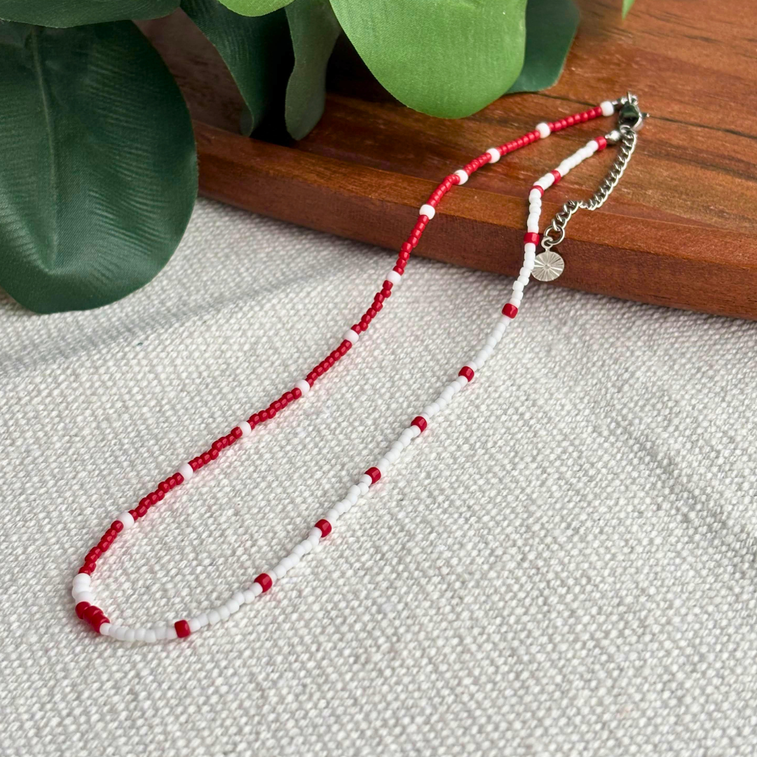 Colier Martisor rosu-alb din margele mici, lucrat manual, design minimalist si usor. Cadou perfect pentru 1 Martie si 8 Martie, ideal pentru tinute de zi cu zi.