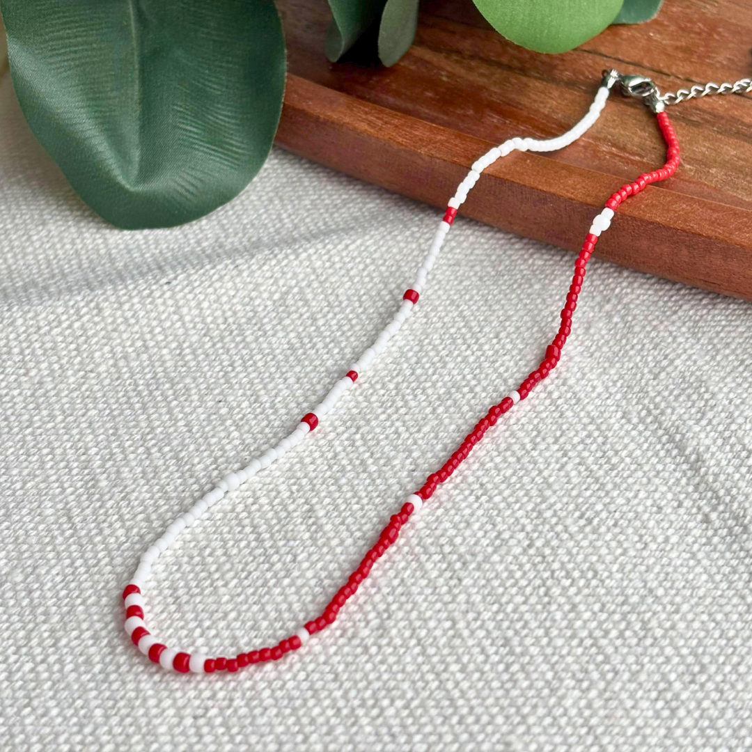 Colier Martisor rosu-alb din margele fine, realizat manual, model minimalist cu inchizatoare si lant prelungitor. Cadou delicat de 1 Martie pentru ea, perfect de purtat zilnic.