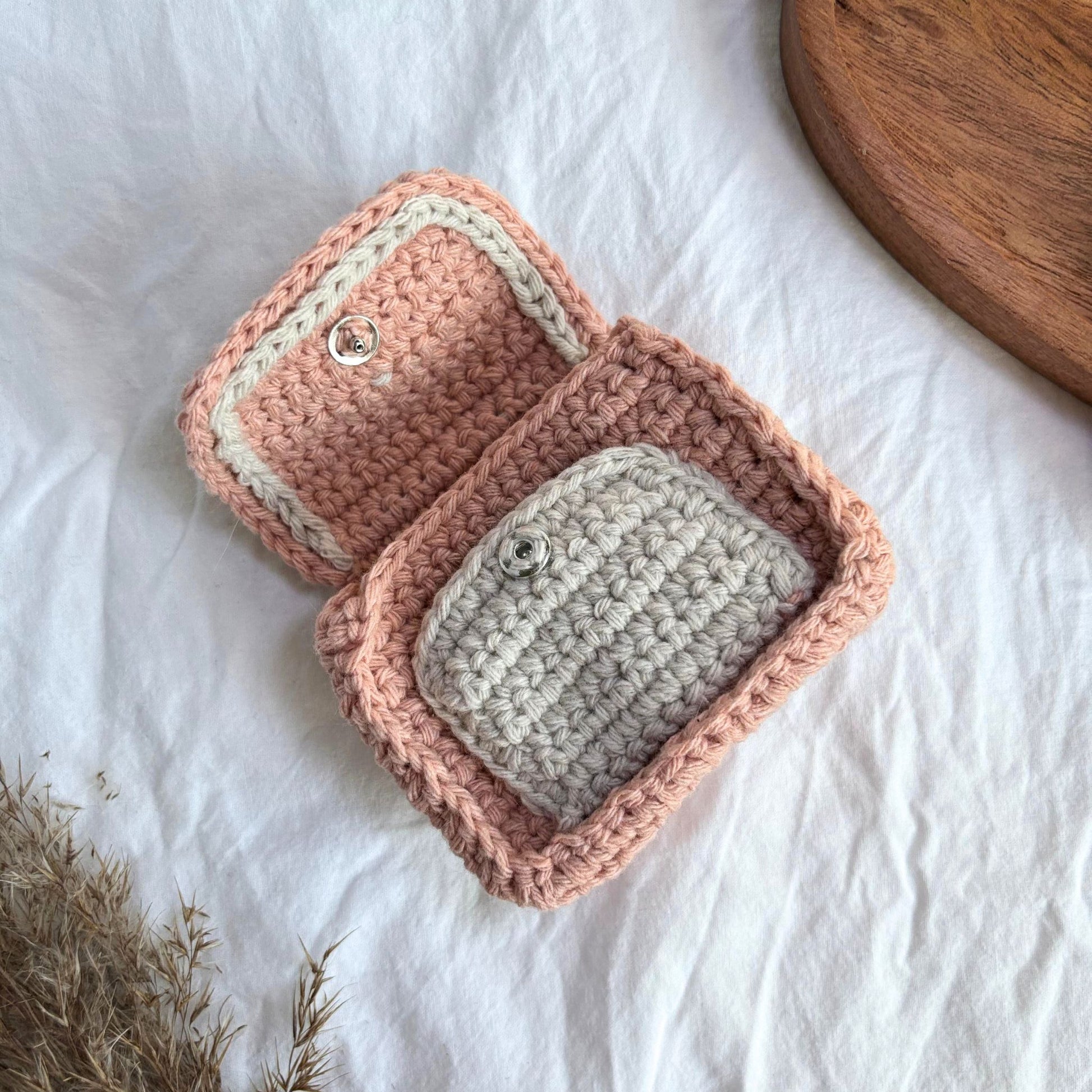 Gentuță mică croșetată handmade, realizată manual din fir textil în nuanțe de roz pastel și bej, cu închidere tip capsă, ideală ca portofel sau mini geantă pentru monede, carduri și obiecte esențiale, accesoriu artizanal și idee de cadou pentru femei.