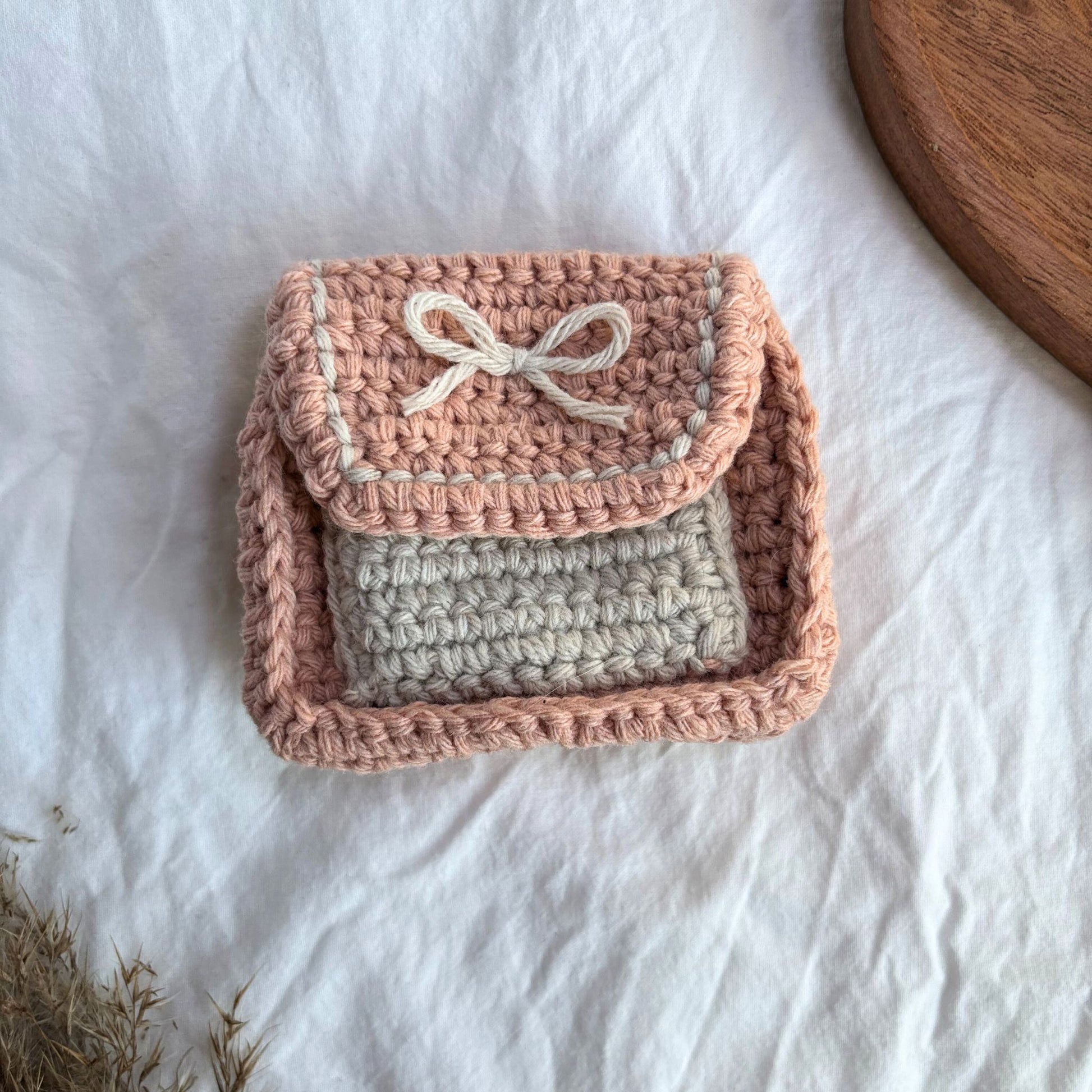 Gentuță croșetată handmade, realizată manual din fir textil în nuanțe de roz pastel și bej, cu clapă decorativă și șnur, ideal pentru monede, carduri sau mici accesorii, cadou artizanal și accesoriu minimalist pentru femei.