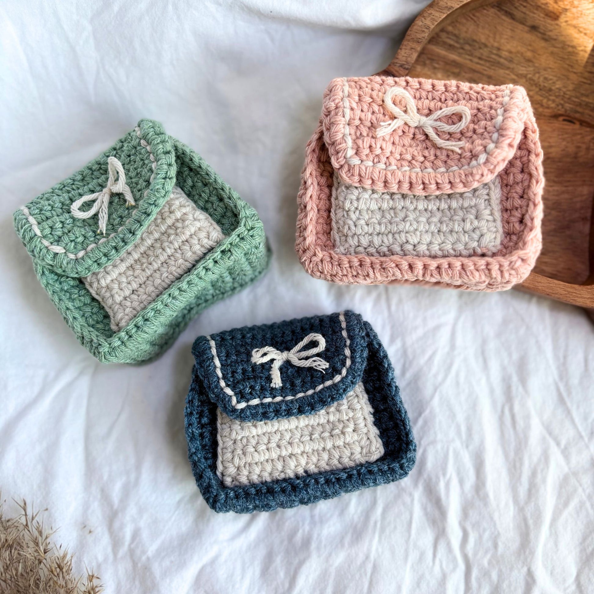 Set de gentuțe mici croșetate handmade, realizate manual din fir textil, în nuanțe pastel de verde, roz și albastru, cu clapă și șnur decorativ, potrivite ca portofel sau mini geantă pentru monede, carduri și obiecte esențiale, accesorii artizanale ideale pentru cadou.