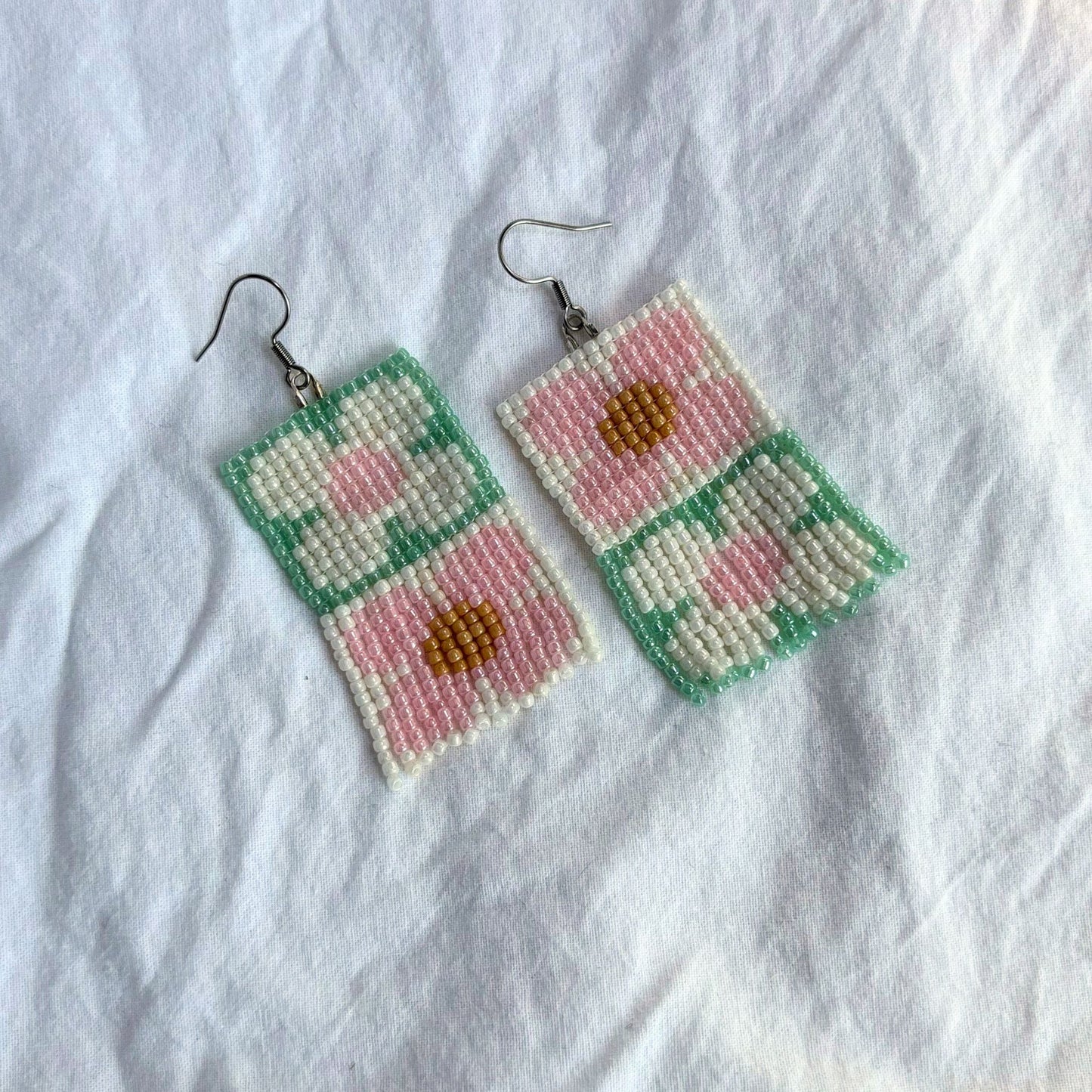 cercei lucrati manual din margele delicate, cu franjuri lungi, in culori paste de verde, roz si crem, cu design geometric si floral boho-modern, bijuterii statement artizanale usoare si elegante, ideale pentru tinute casual sau elegante, cadouri pentru femei