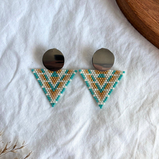 cercei lucrati manual din margele delicate, model geometric statement tip triunghi cu accesoriu rotund metalic, in nuante pastel de turcoaz, portocaliu si alb perlat, cercei statement usori, bijuterii artizanale unicat, ideali pentru cadou, tinute de zi si evenimente speciale.