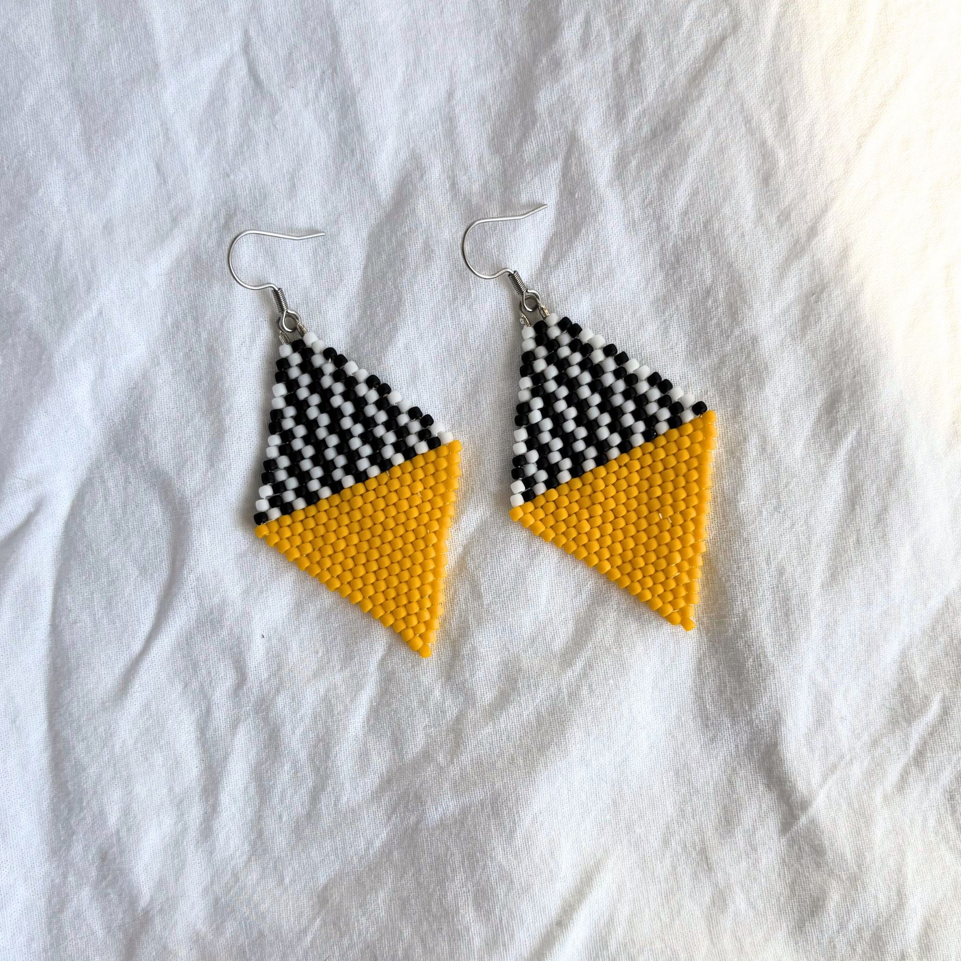 Cercei handmade din margele delicate, in combinatie de galben cu alb si negru, cercei statement usori, bijuterii artizanale unicat, stil modern contemporan, design geometric tip romb, potriviti pentru cadou, in tinute casual de zi sau pentru ocazii si evenimente speciale.