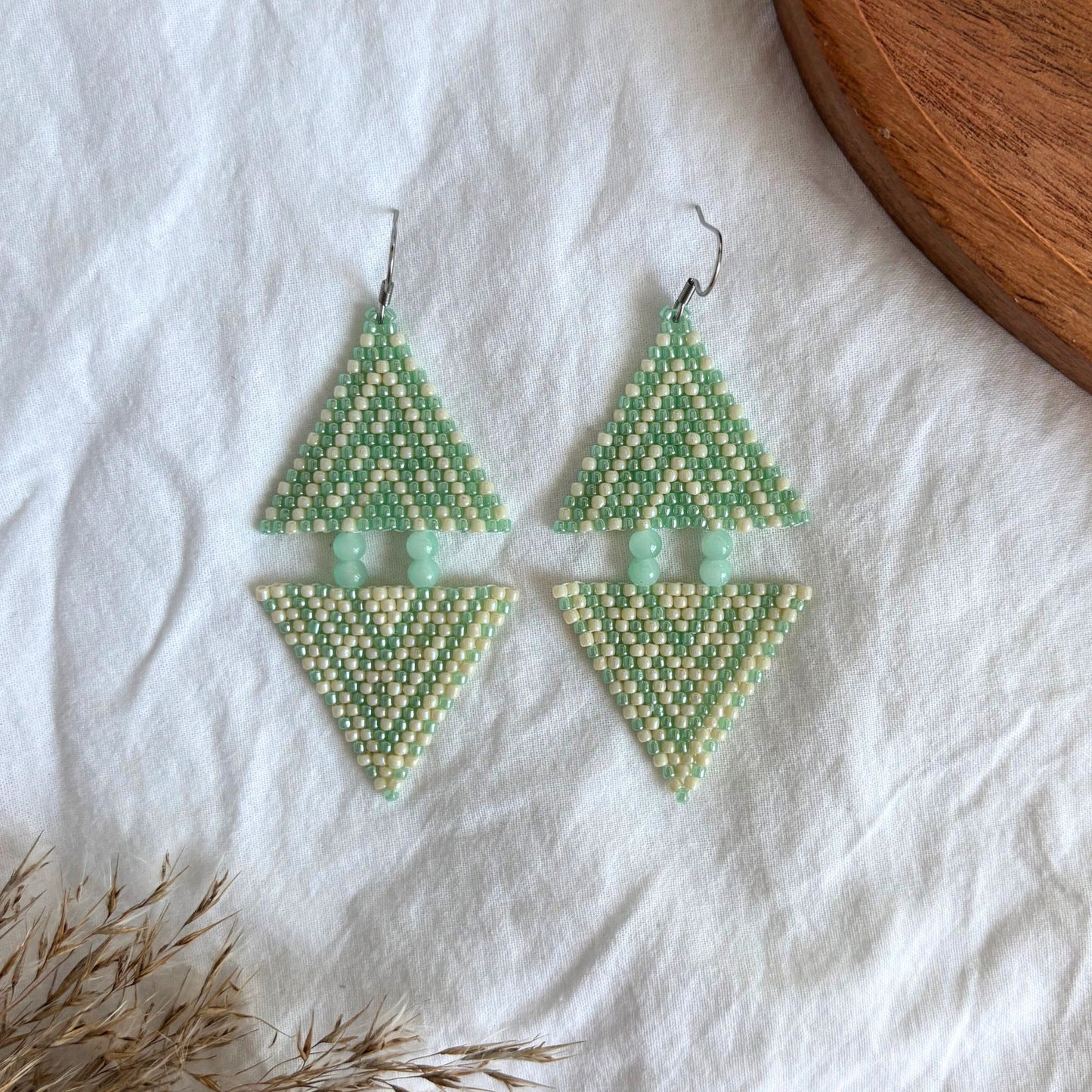 cercei realizati manual din margele delicate verde pastel si bej, cu model geometric simetric si margele verde menta, bijuterii artizanale originale, model unicat si elegant, accesorii usoare potrivite pentru tinute de vara, boho sau casual, cadou pentru femei